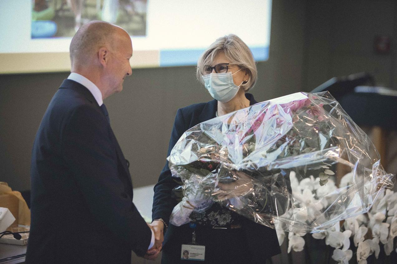 Christina Odermatt, langjährige Sekretärin von Thomas Neuhaus, überreicht ihm einen Blumenstrauss. 