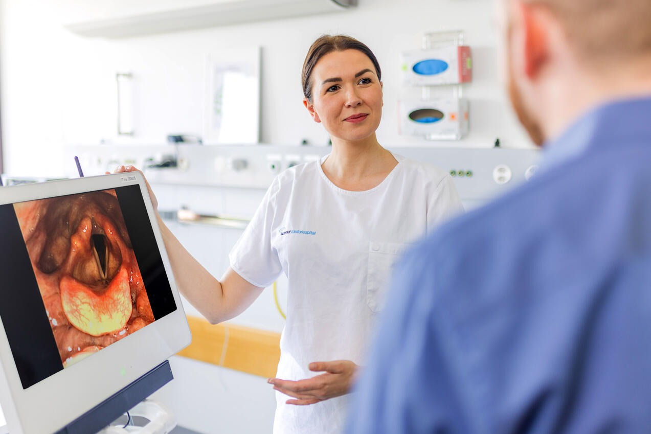 Jana Jungblut zeigt einem Patienten ein Bild seiner Stimmbänder. 