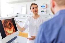 Jana Jungblut zeigt einem Patienten ein Bild seiner Stimmbänder. 